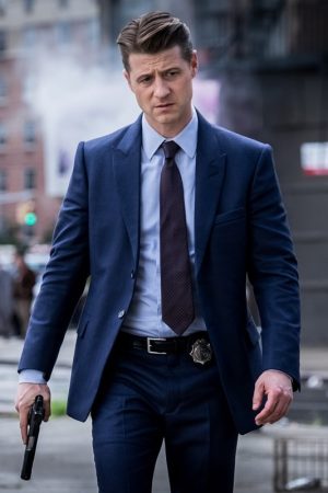 Actor Ben McKenzie TV Drama Gotham James Gordon Wearing a Stylish Blue Suit he holding Gun in a Right-hand