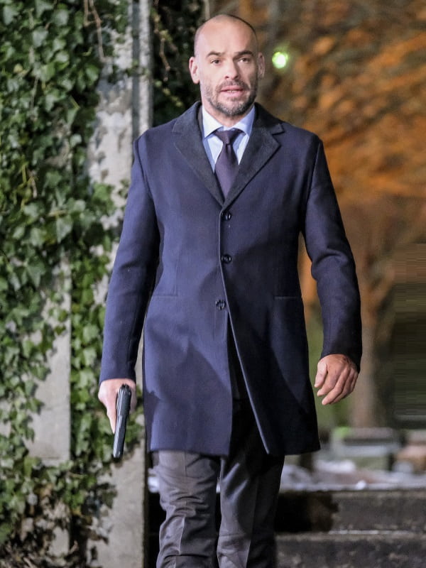Paul Blackthorne Wearing A Navy Blue Color Styish Wool Coat In Dama Series Arrow he holding a gun in right hand
